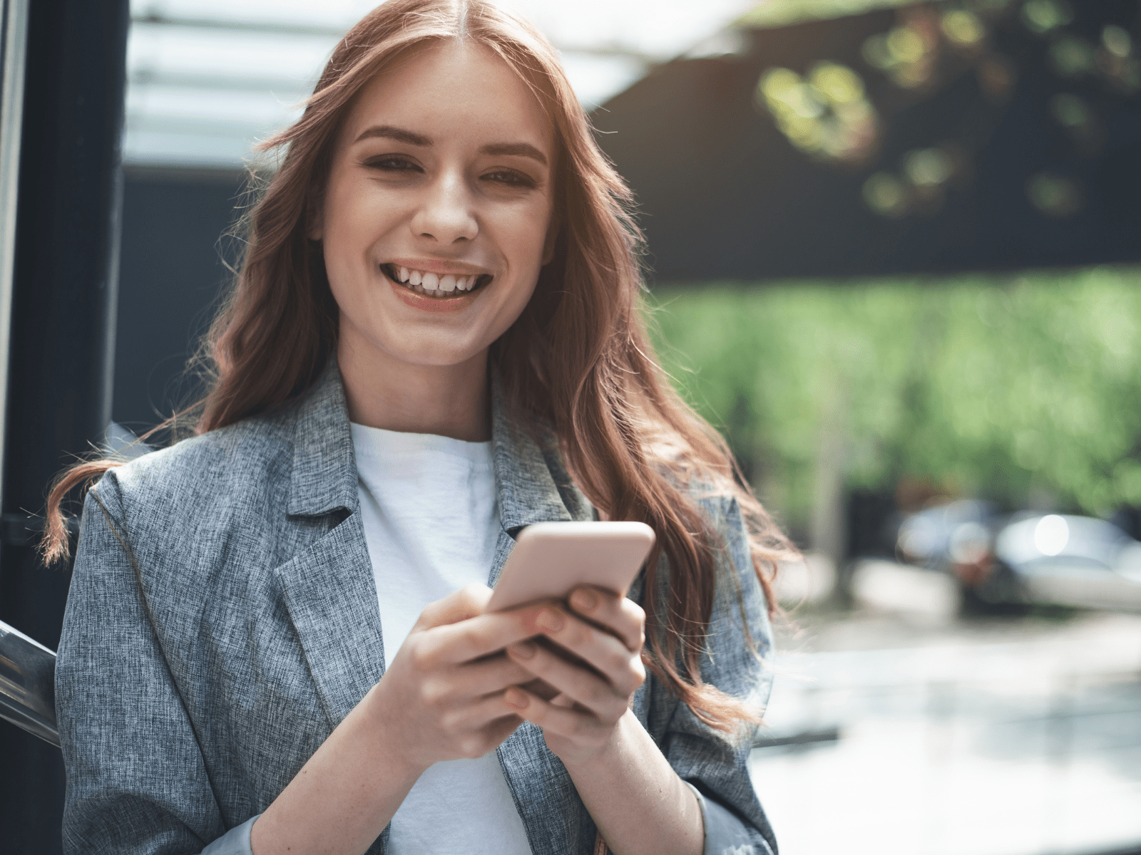 young woman smiling holding her mobile phone