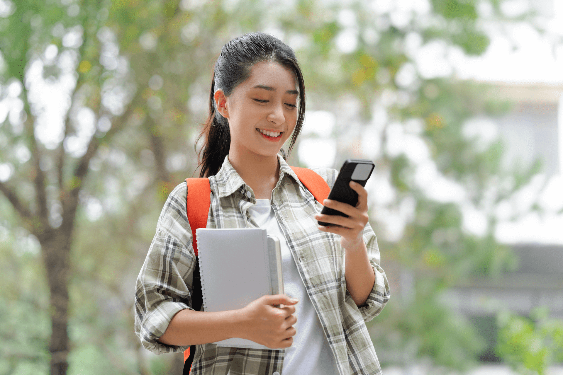 Happy student looking down at her phone